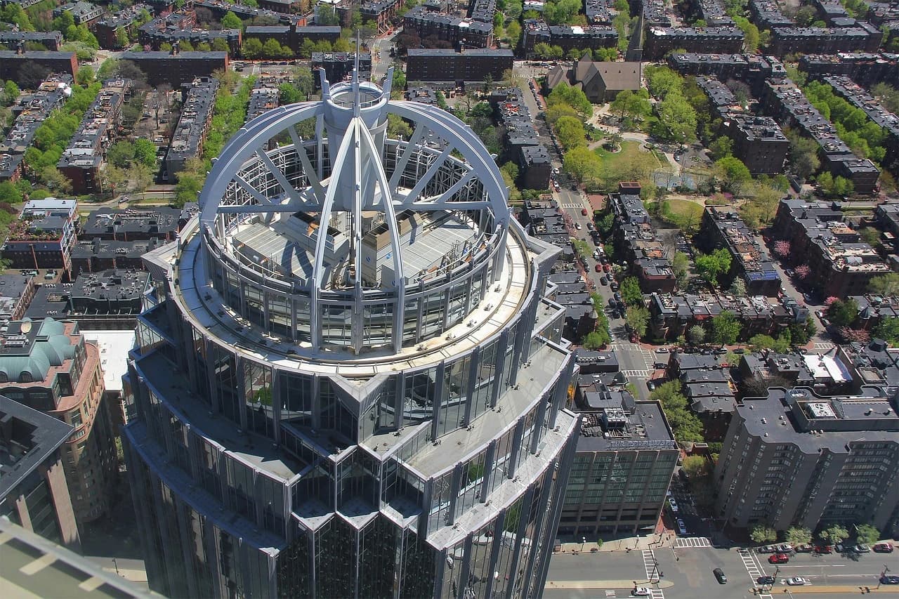 The distinctive dome and circular building of the Massachusetts State House are framed by the modern skyscrapers of the city.