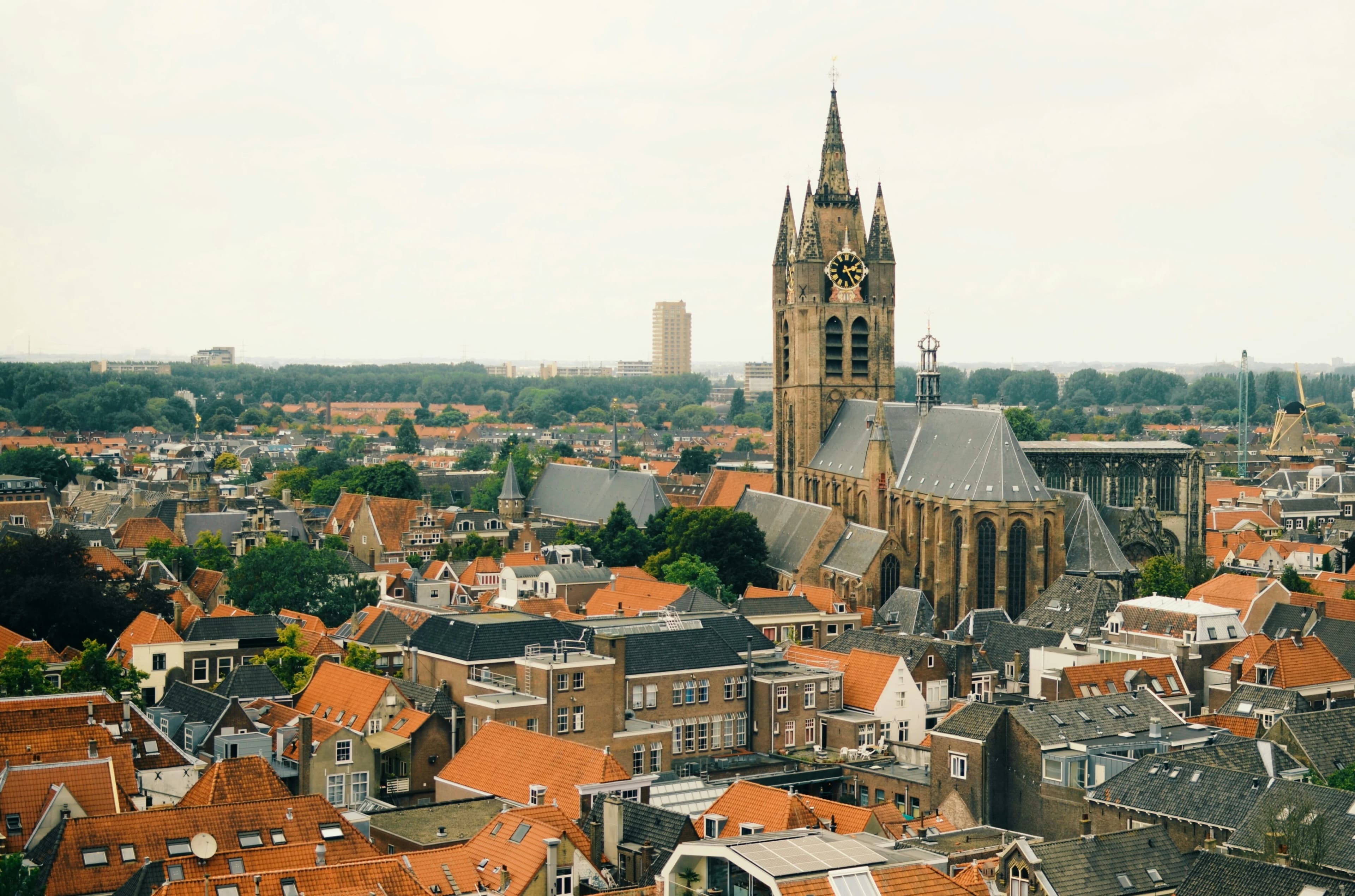 An aerial view of Delft’s cityscape, with the striking New Church (Nieuwe Kerk) tower rising above the red rooftops.