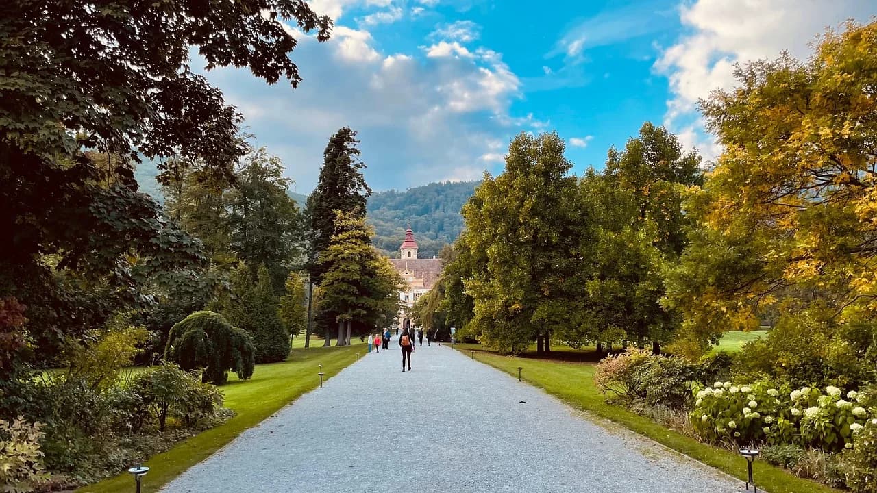 A long, tree-lined path leads to the majestic Eggenberg Palace, a beautiful baroque-style palace on the outskirts of Graz.