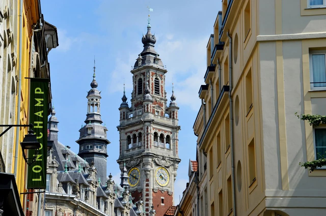 The ornate belfry of the Chamber of Commerce and Industry rises above the rooftops of Lille's bustling city center.