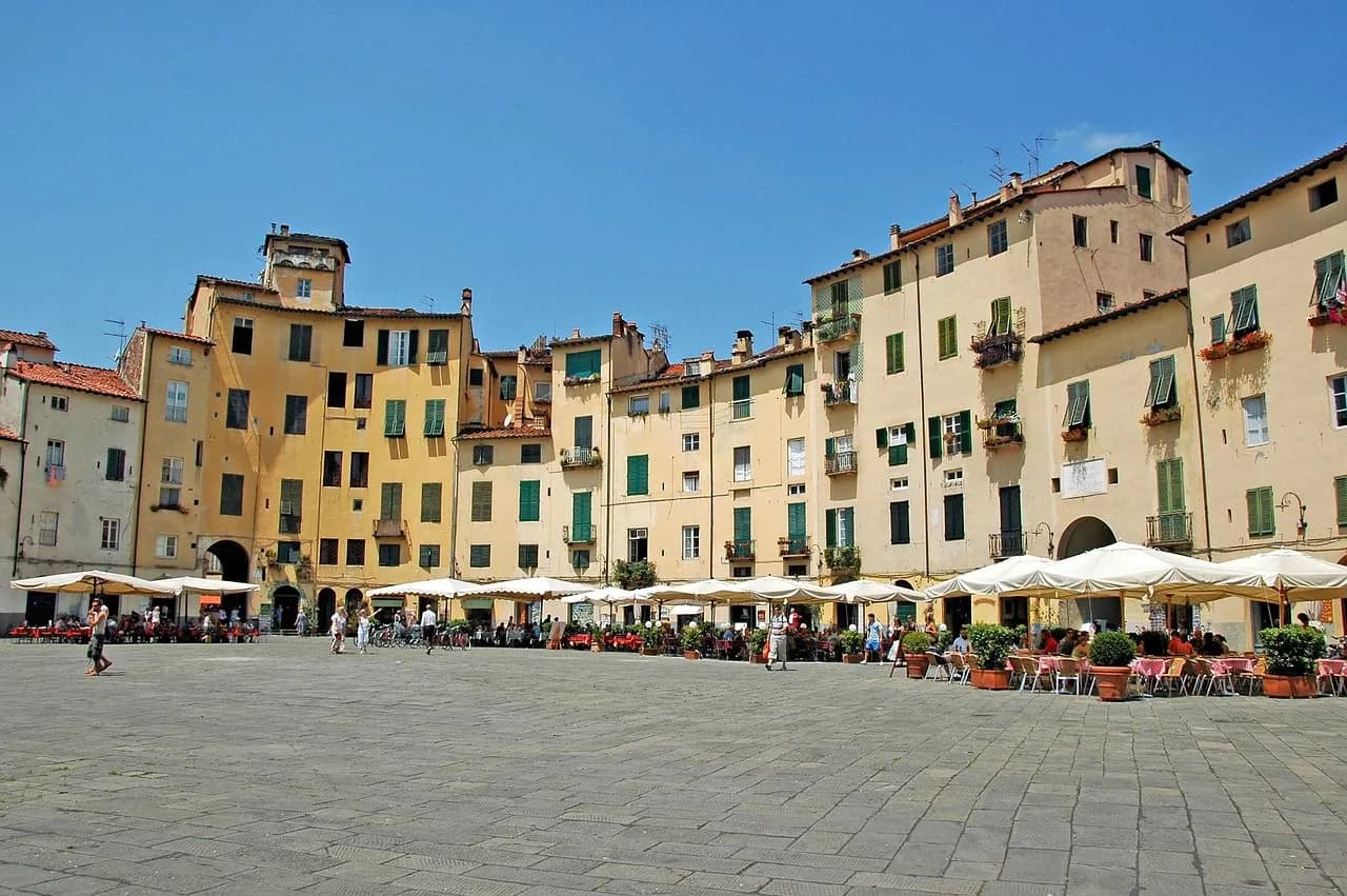 A large, historic square is lined with traditional buildings and bustling outdoor cafes.