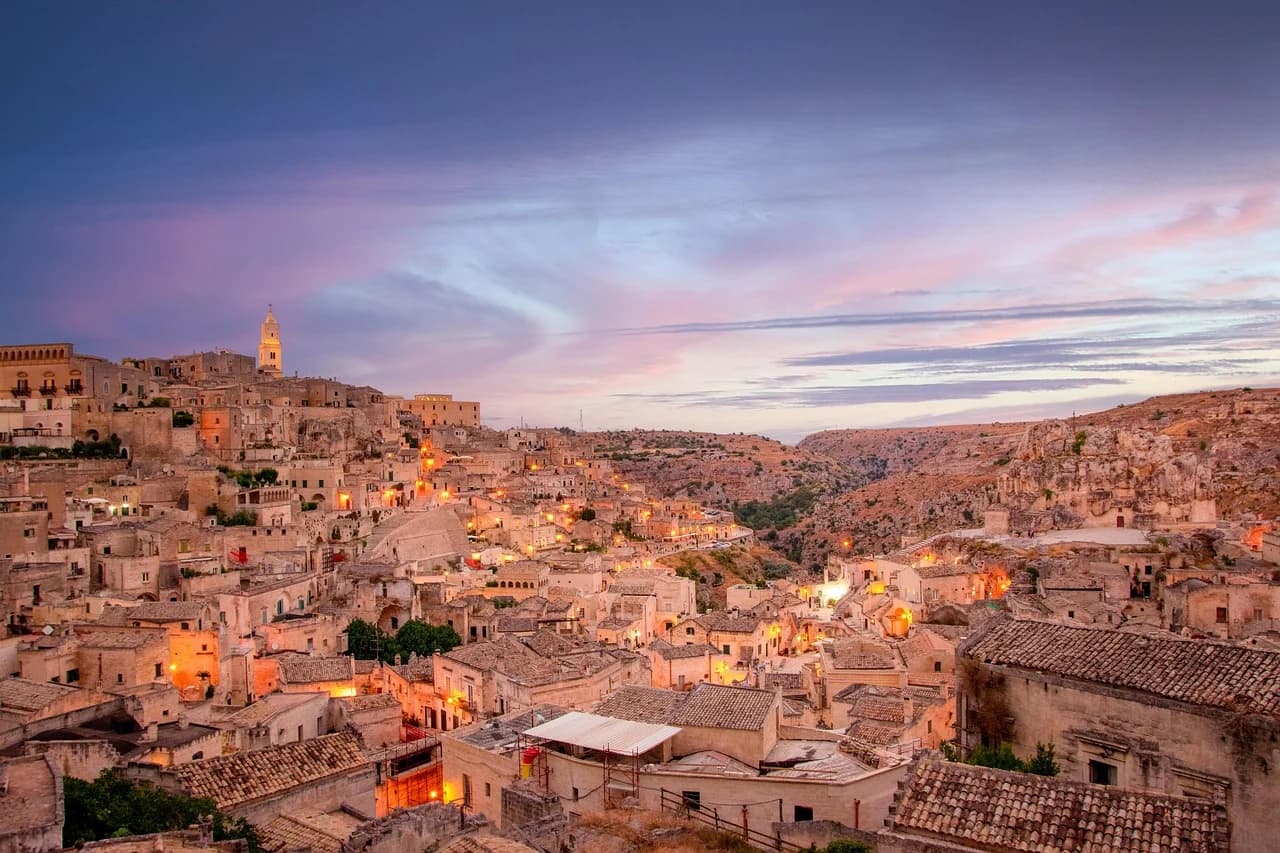 A panoramic view of the Sassi di Matera, a UNESCO World Heritage site, with its ancient cave dwellings and a church built into a rock.