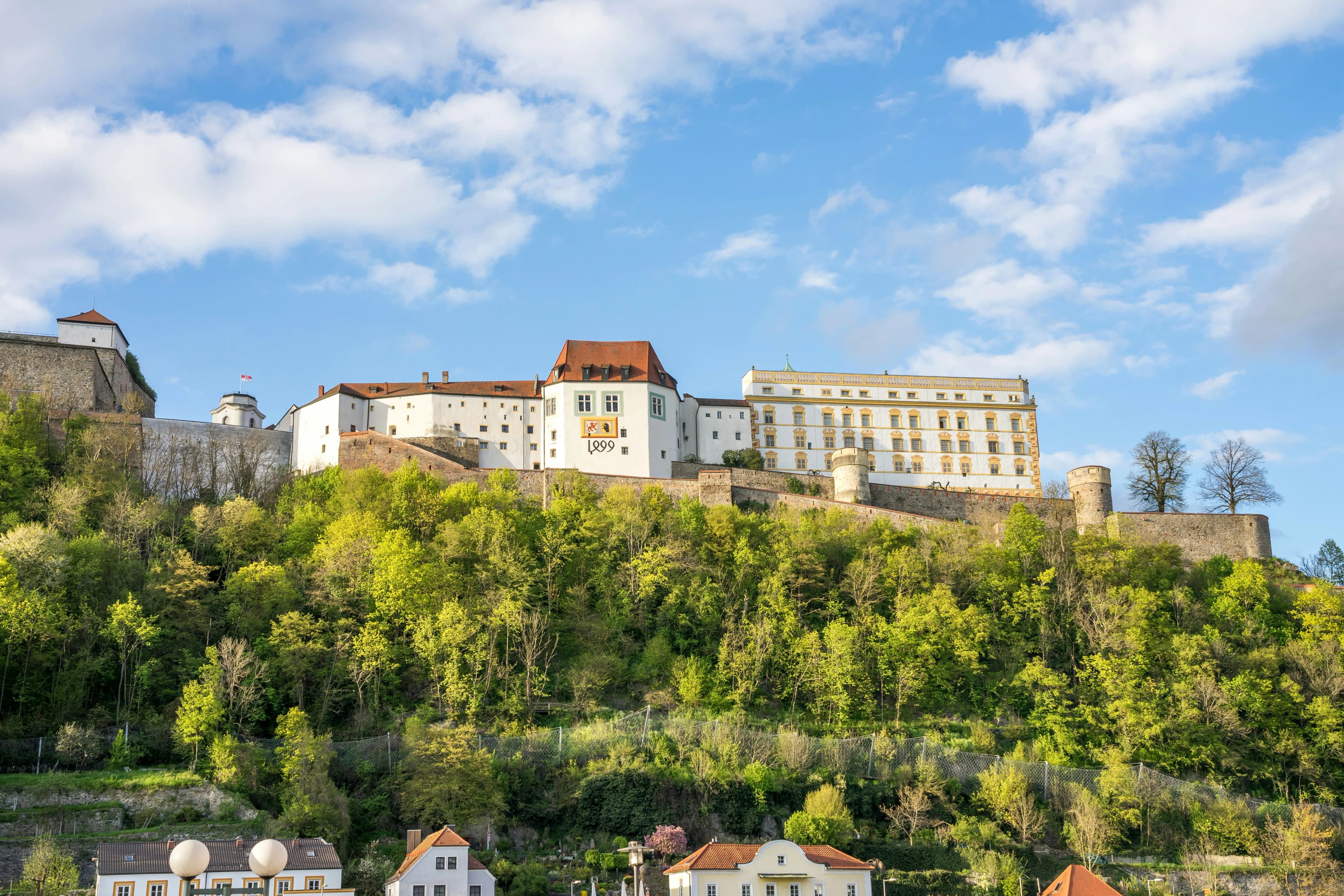 The Veste Oberhaus, a large medieval fortress, stands on a hill overlooking the city of Passau and the Danube River.
