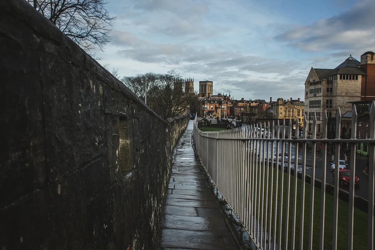 A view from the ancient York city walls reveals the winding path and the striking architecture of York Minster in the distance.